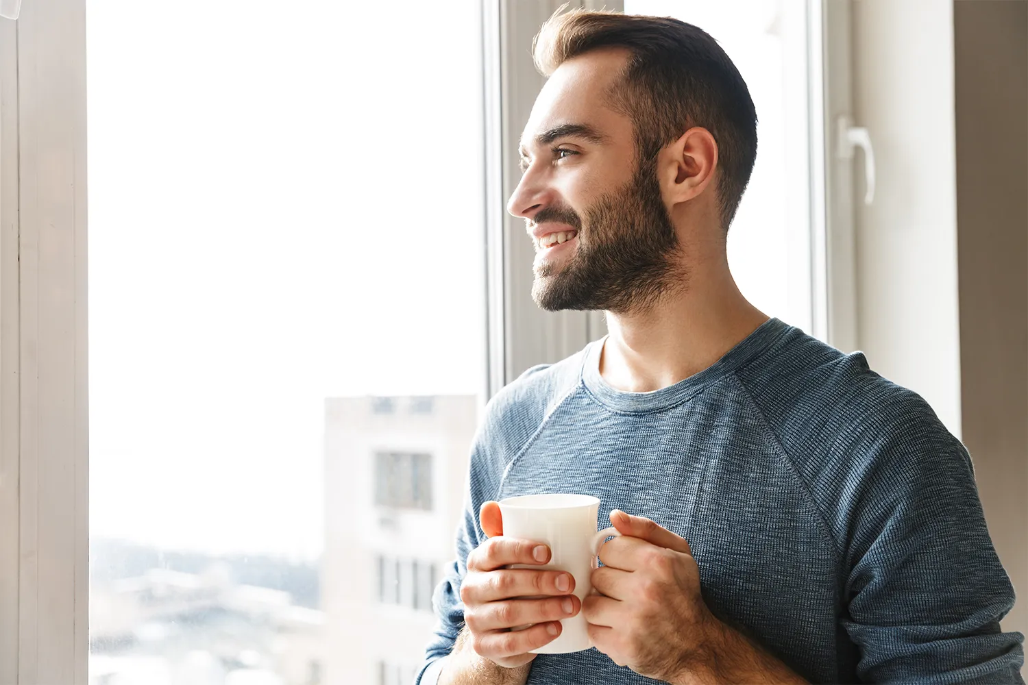 Man looking hopeful with a cup of coffee